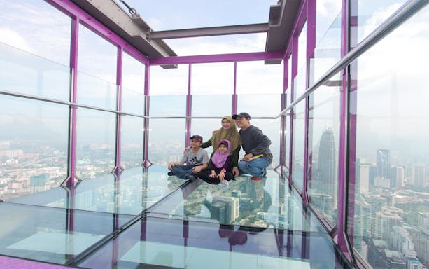 Family enjoying the view from KL Tower SkyBox in Kuala Lumpur.
