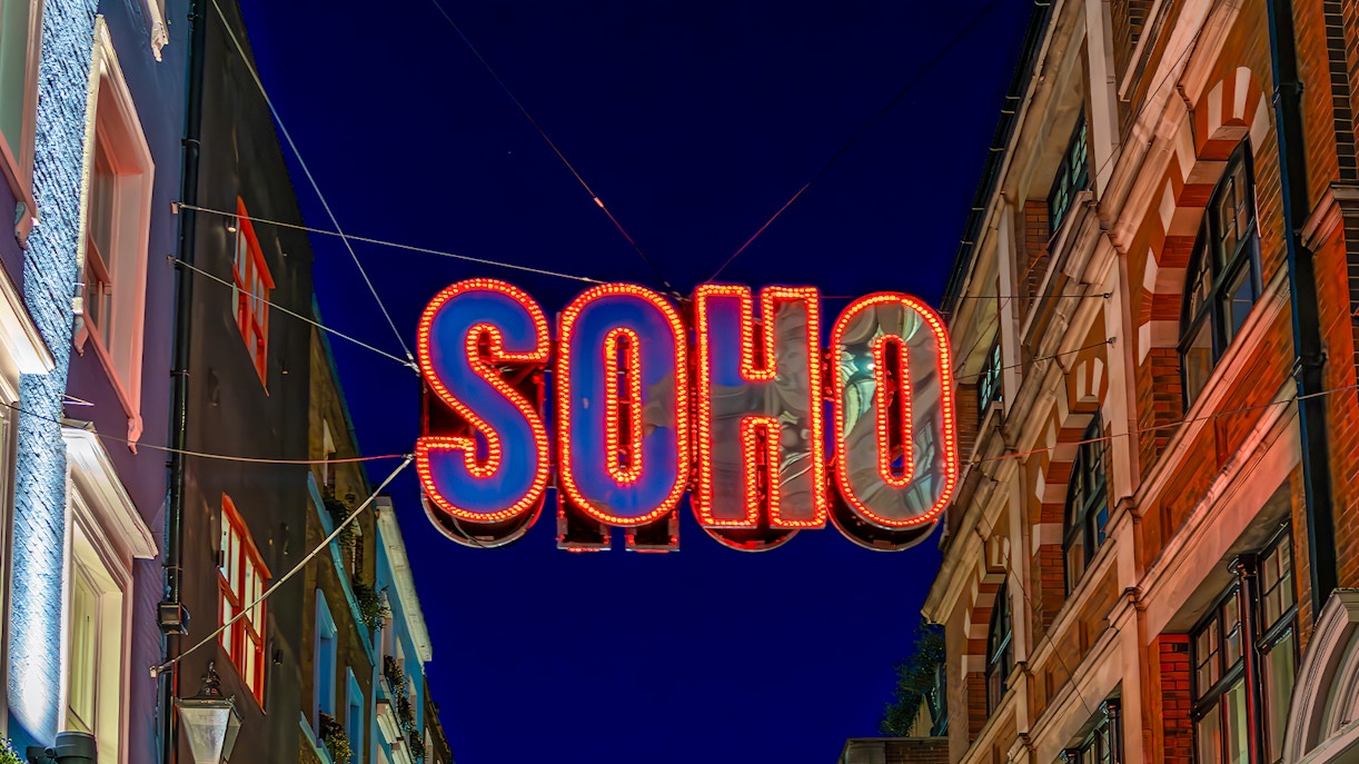 Soho neon sign at night, London street scene.