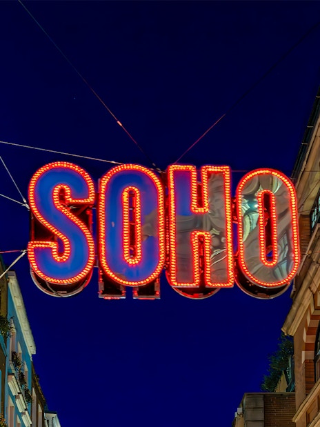 Soho neon sign at night, London street scene.