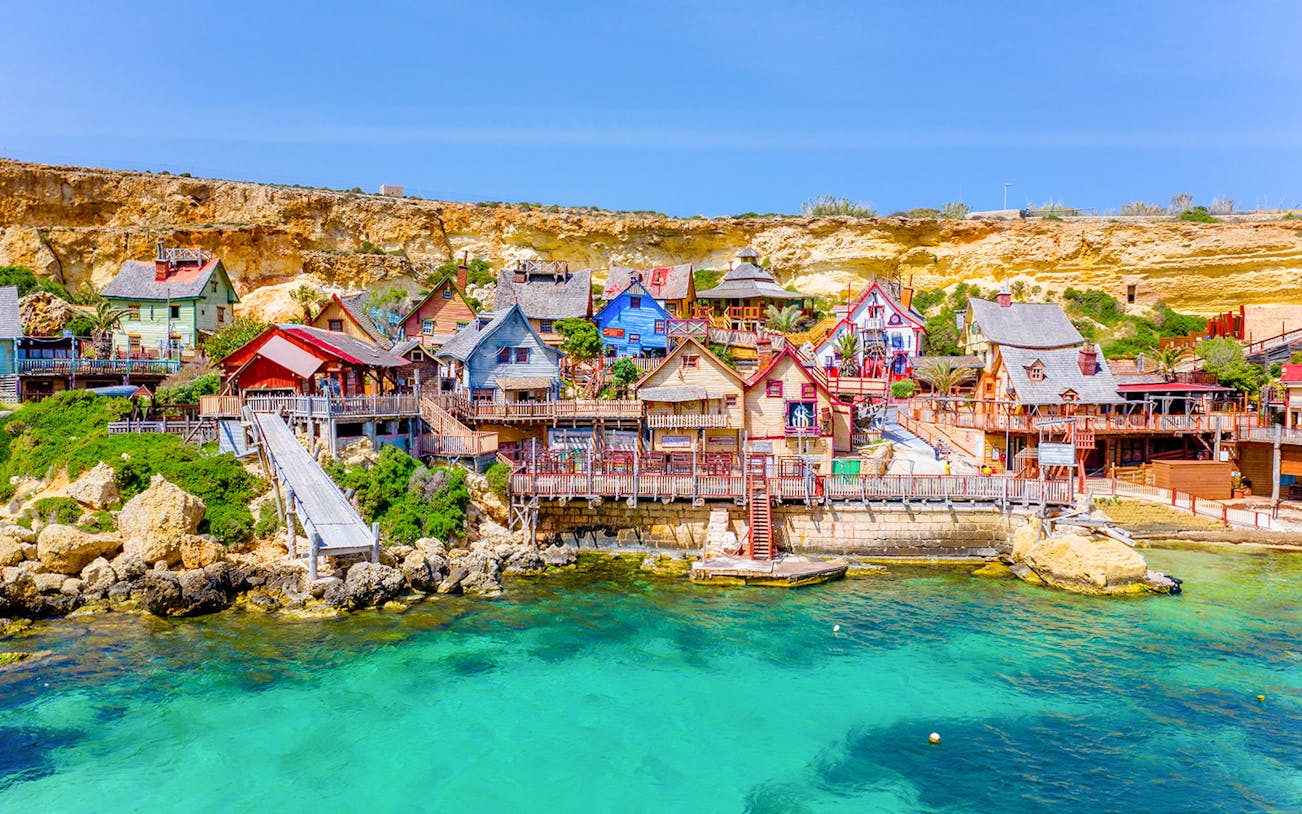 Aerial view of colorful wooden buildings at Popeye Village, Malta.