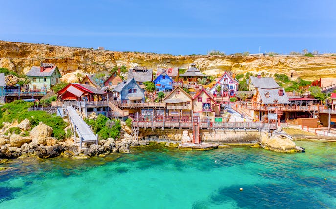 Aerial view of colorful wooden buildings at Popeye Village, Malta.