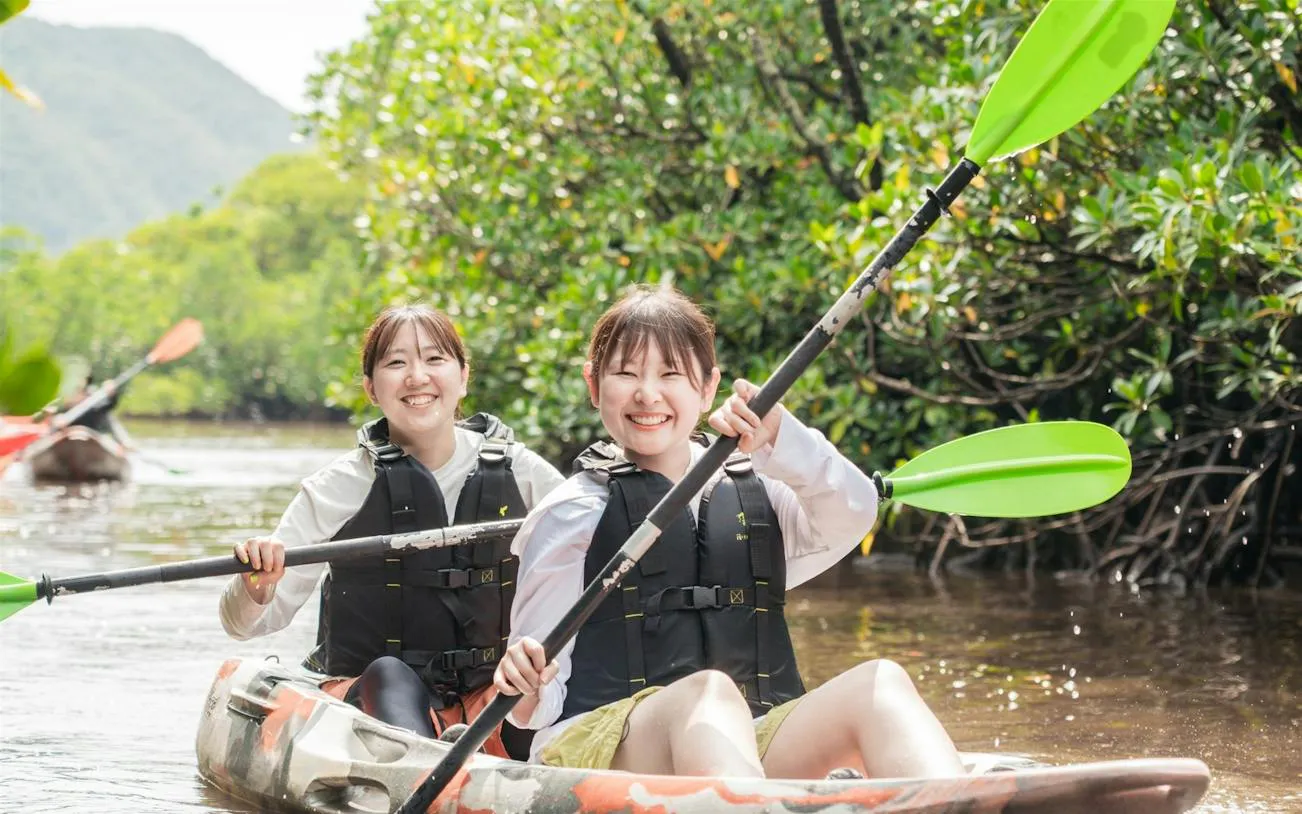 Two people kayaking through mangroves on Iriomote Island, Okinawa.