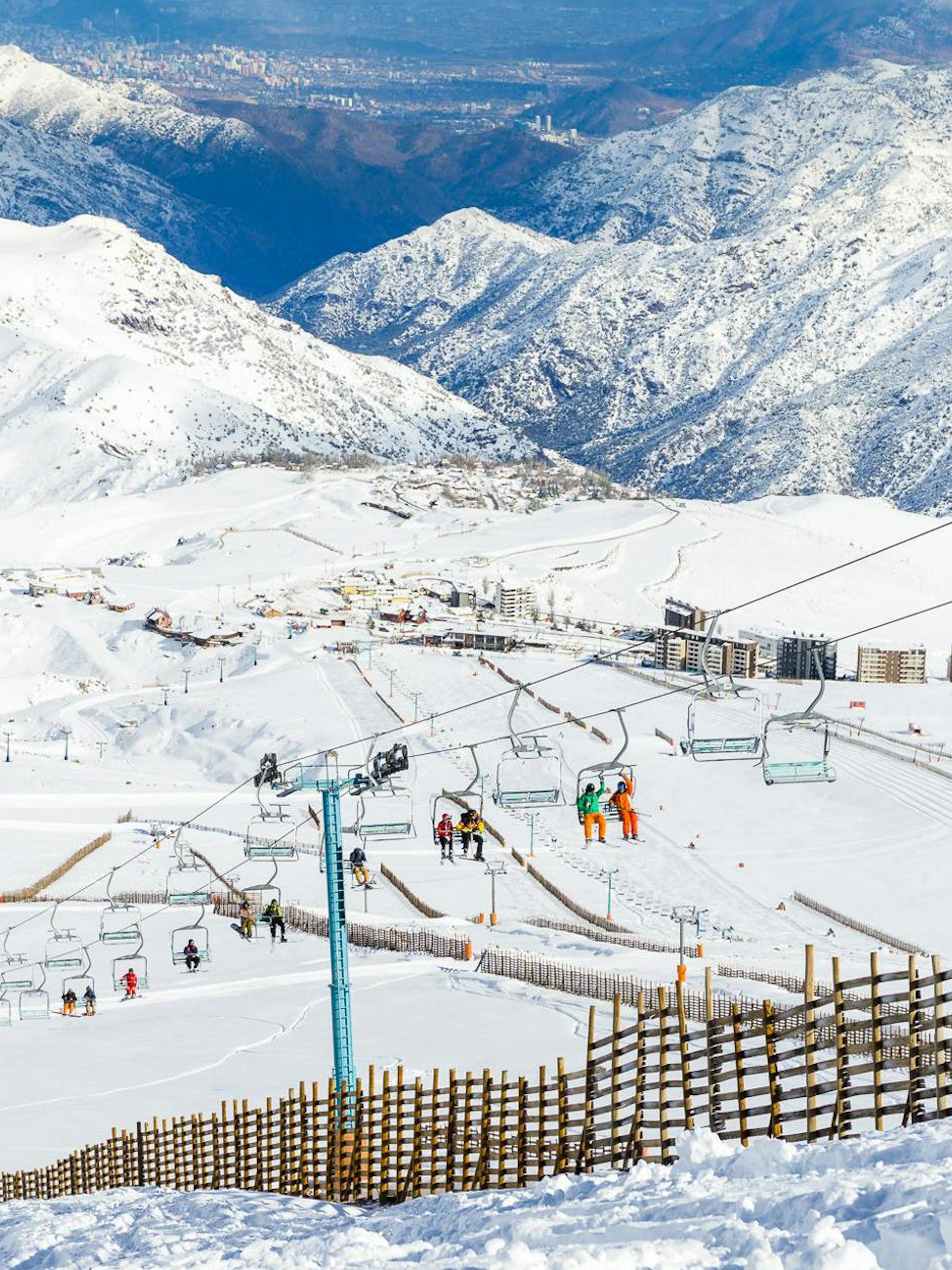 Ski lift ascending snowy slopes at Farellones Ski with mountain backdrop.