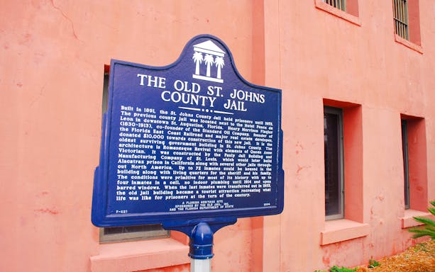 Old St. Johns County Jail sign in St. Augustine, highlighting historical significance.