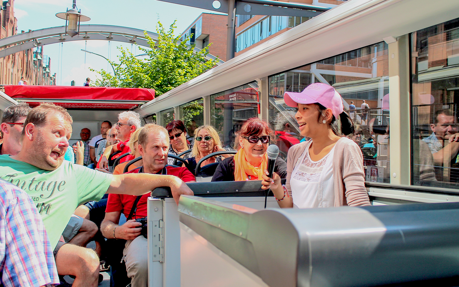 Tour guide speaking to passengers on a city bus tour.
