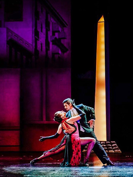 Dancers performing at Tango Porteño Show in front of a lit backdrop.