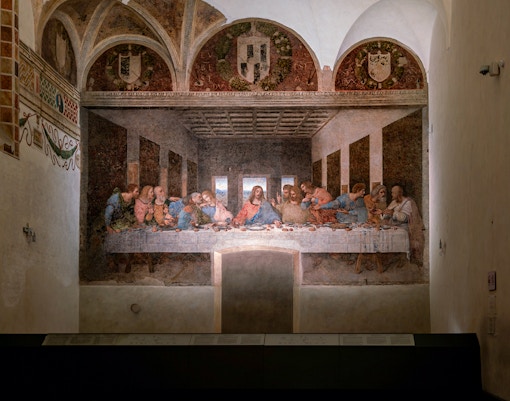 Visitors viewing Da Vinci's Last Supper fresco in Milan's Santa Maria delle Grazie.