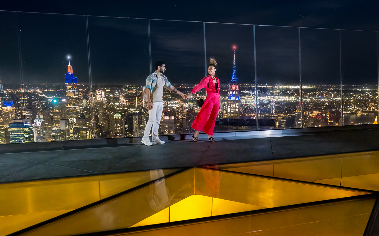 Couple enjoying night view from Edge Observation Deck, New York City.