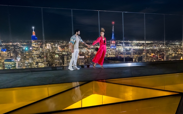 Couple enjoying night view from Edge Observation Deck, New York City.