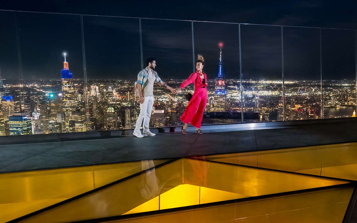 Couple enjoying night view from Edge Observation Deck, New York City.