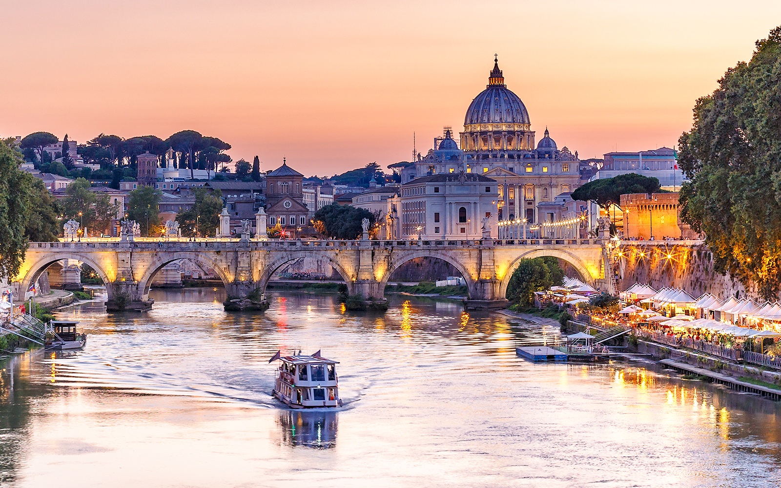 Cruise on the Tiber River with St. Peter's Basilica in Rome at sunset.