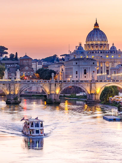 Cruise on the Tiber River with St. Peter's Basilica in Rome at sunset.