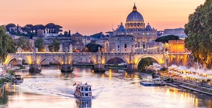Cruise on the Tiber River with St. Peter's Basilica in Rome at sunset.