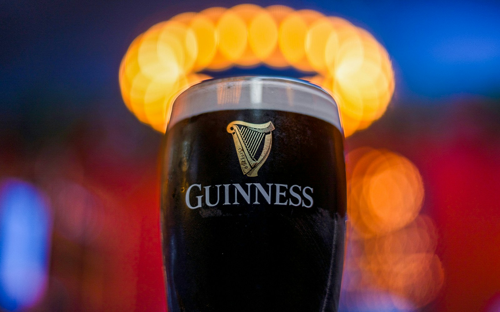 Guinness Storehouse bar taps and guests enjoying mirror illusion in Dublin.