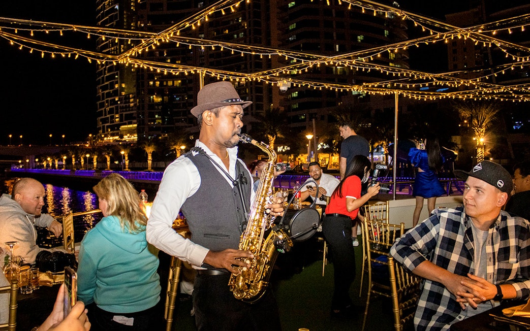 Saxophonist performing on a Dubai Marina sunset cruise with buffet dinner.