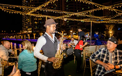 Saxophonist performing on a Dubai Marina sunset cruise with buffet dinner.