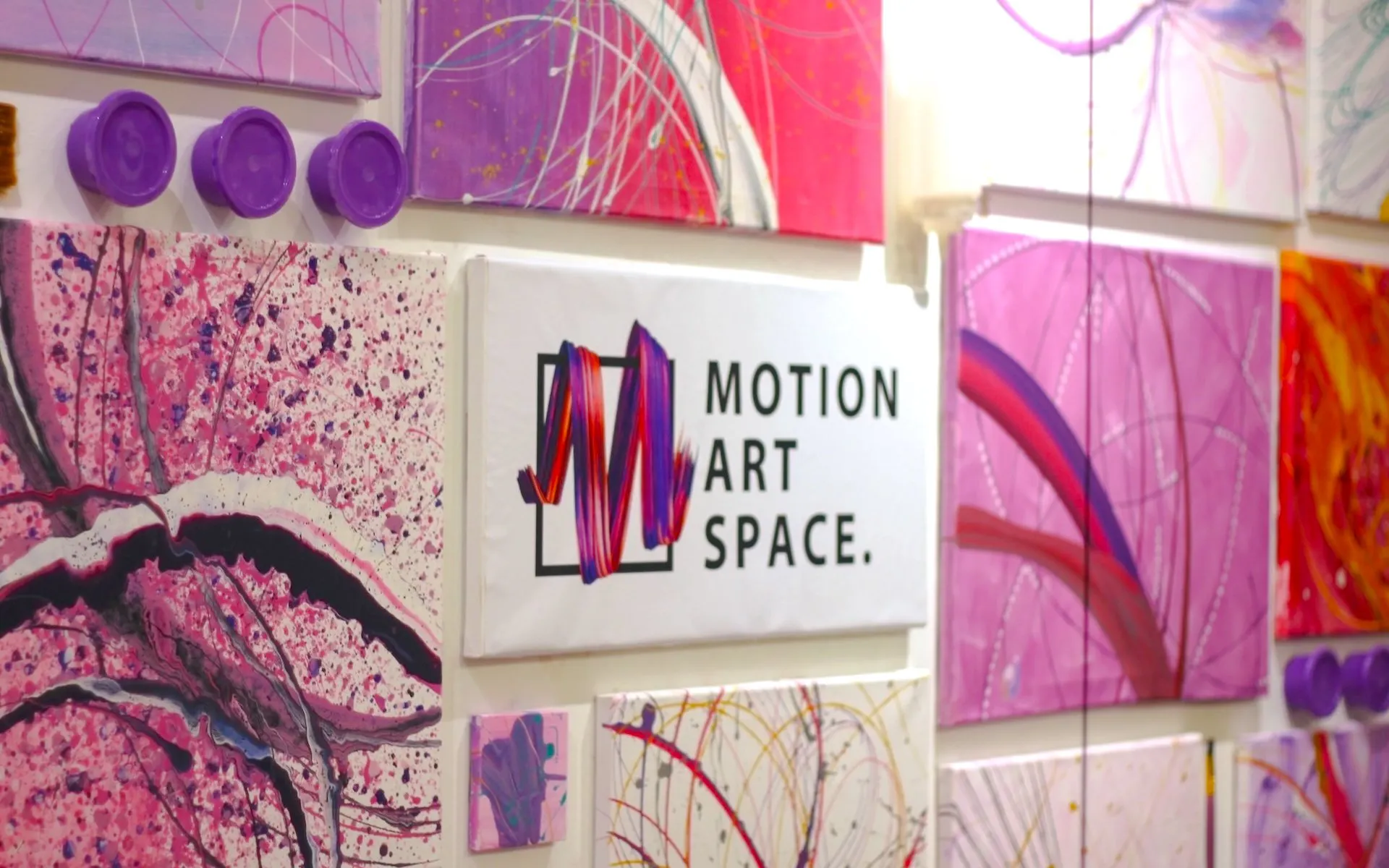 Motion Art Space Singapore wall with abstract pink and purple paintings.