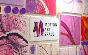 Motion Art Space Singapore wall with abstract pink and purple paintings.