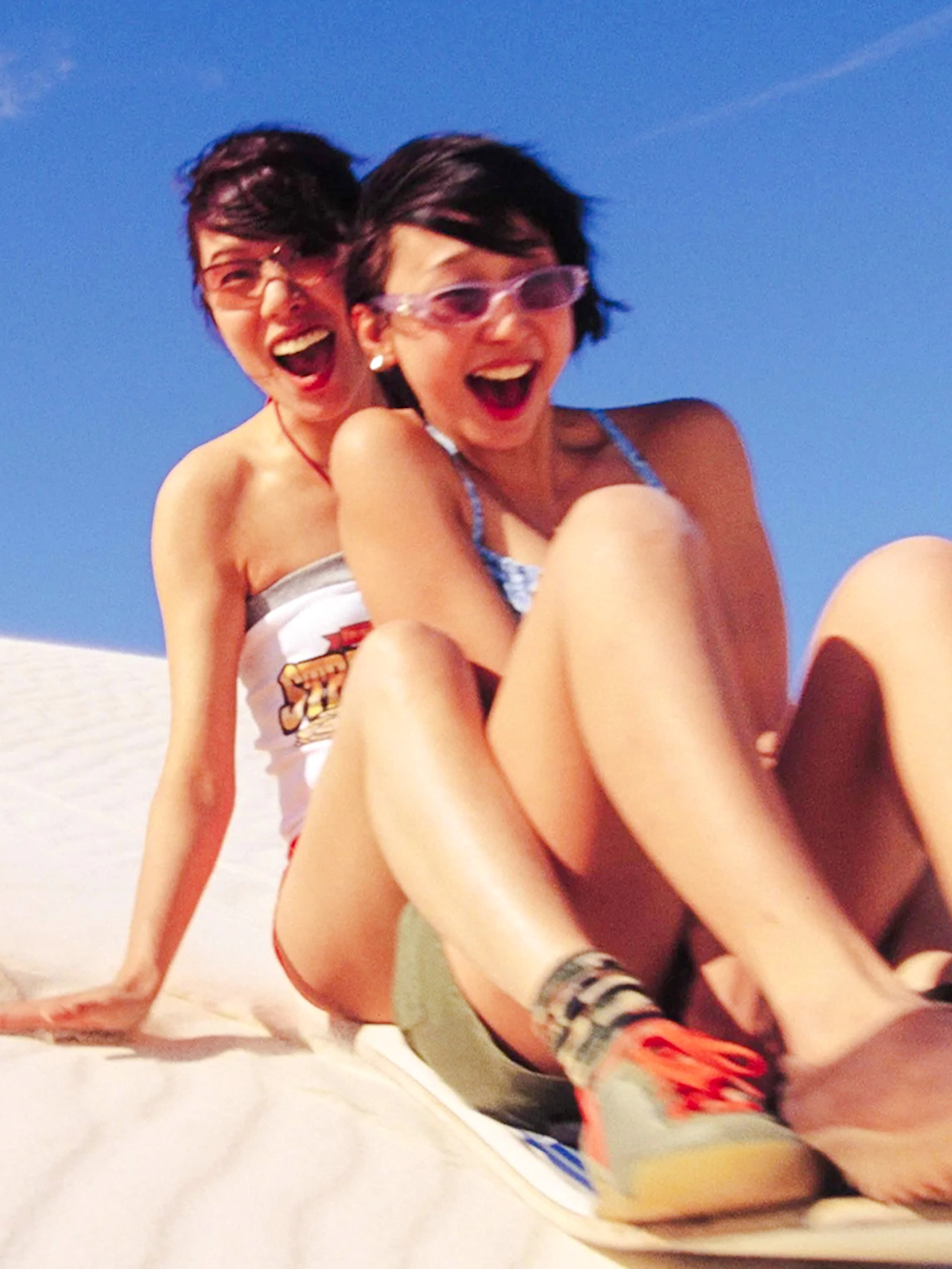 People sandboarding down a dune during a 4WD tour.