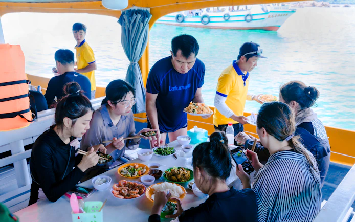 Guests enjoying lunch on a boat during the 3 Island Hopping Tour in Phu Quoc.