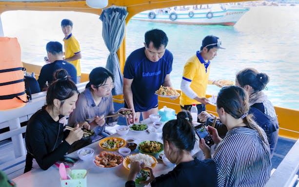 Guests enjoying lunch on a boat during the 3 Island Hopping Tour in Phu Quoc.