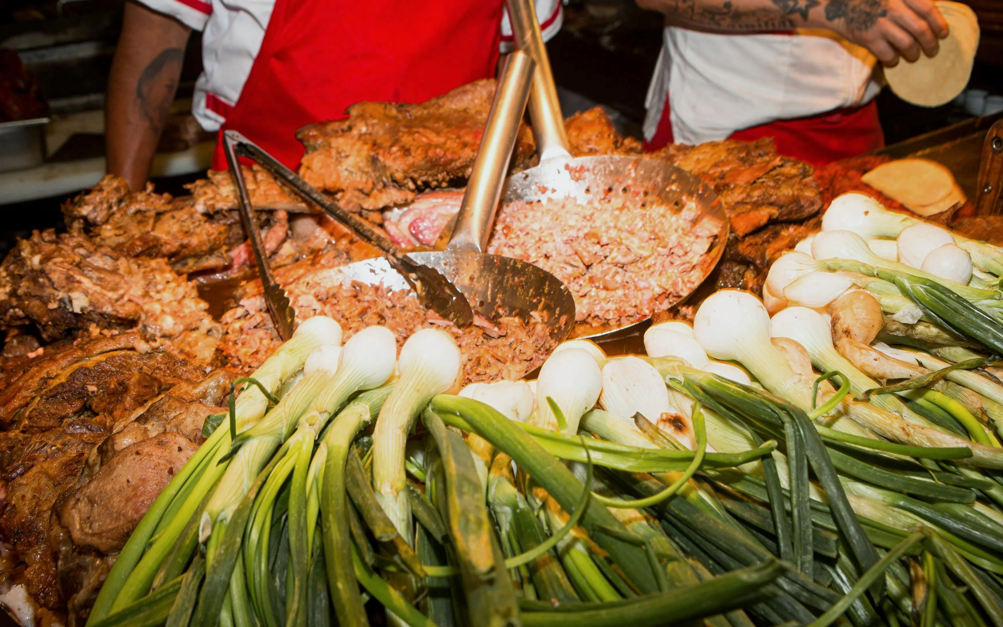 Taco preparation with grilled meat and spring onions in Mexico City.