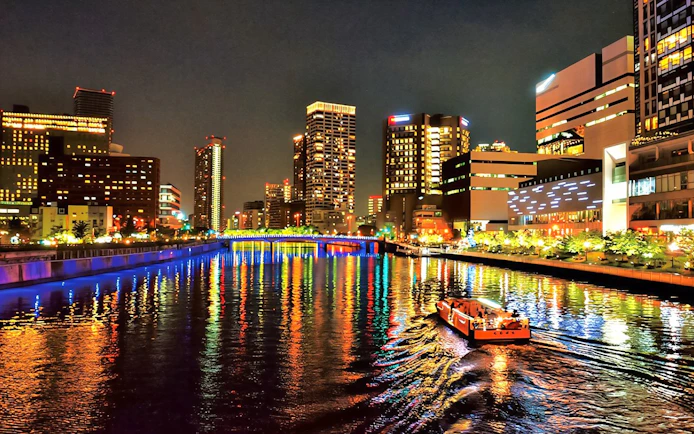 Nakanoshima River Cruise on Dojima River at night, Osaka, Japan, with city lights reflecting on water.