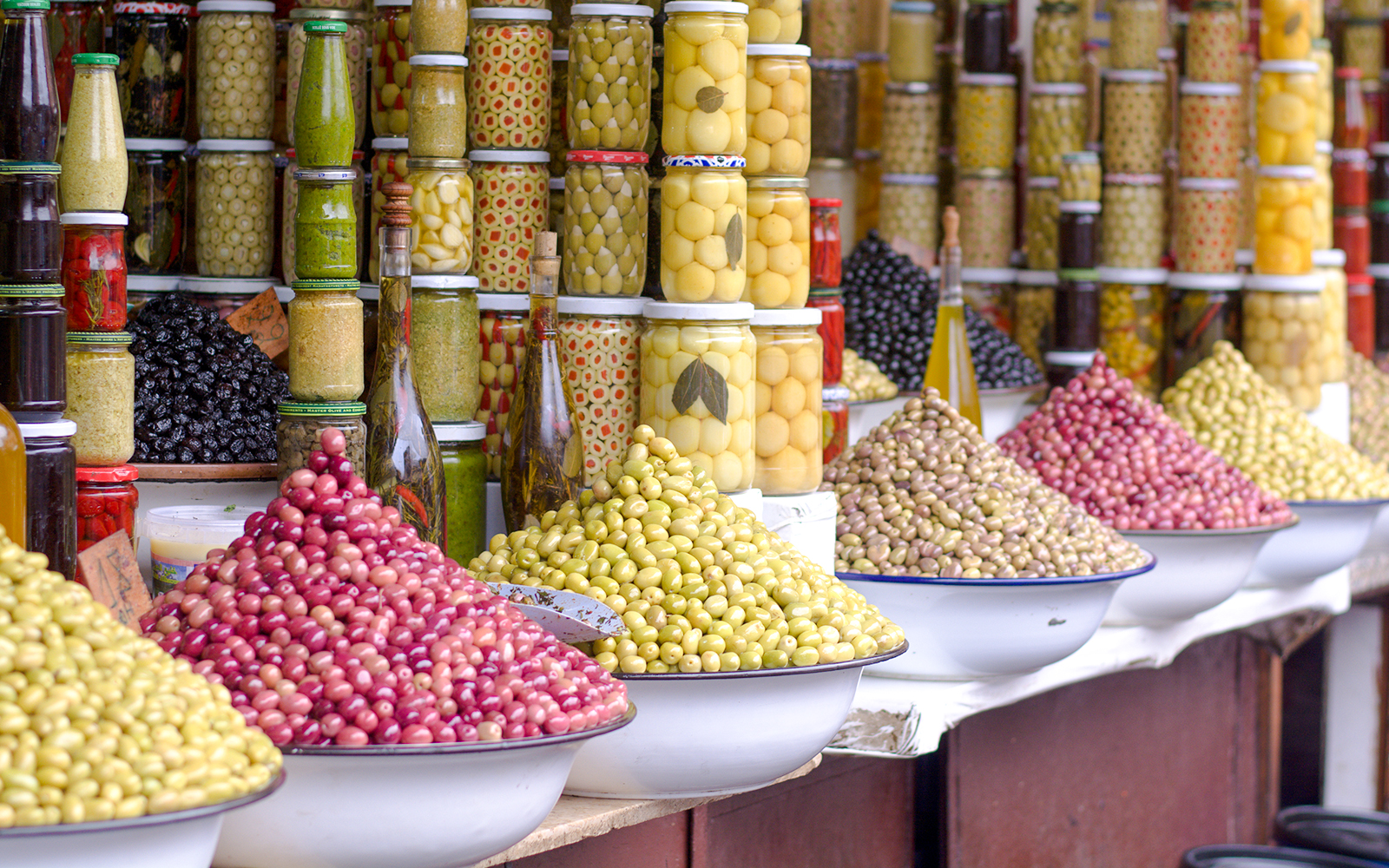 Jars and bowls of olives at a market stall during a Marrakech night walking tour.