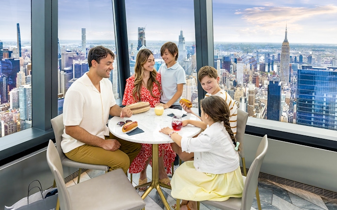 Family dining with city view at Edge Observation Deck, New York City.
