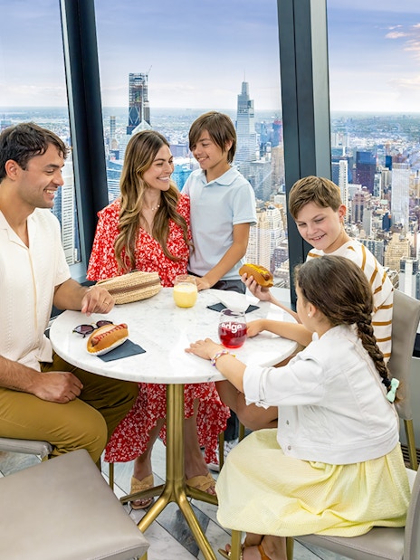 Family dining with city view at Edge Observation Deck, New York City.