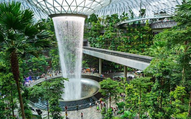 Indoor waterfall and lush greenery at Jewel Changi Airport, Singapore, part of Garden City Pass.