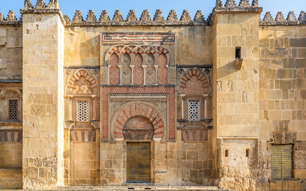 Córdoba Cathedral-Mosque exterior with intricate Moorish arches and detailed stonework.