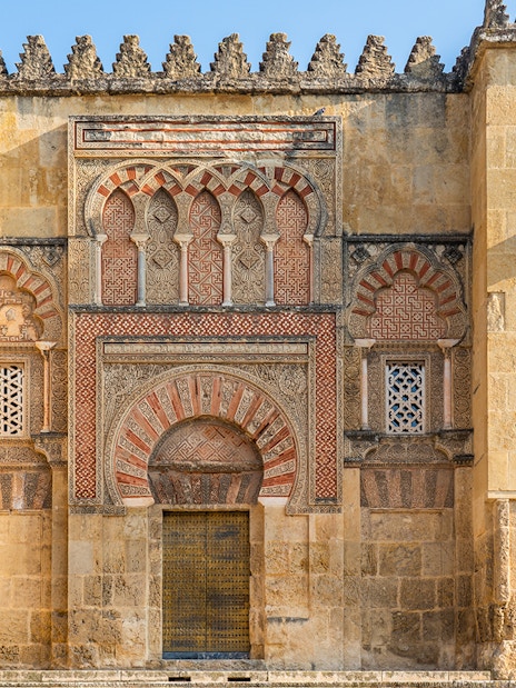 Córdoba Cathedral-Mosque exterior with intricate Moorish arches and detailed stonework.