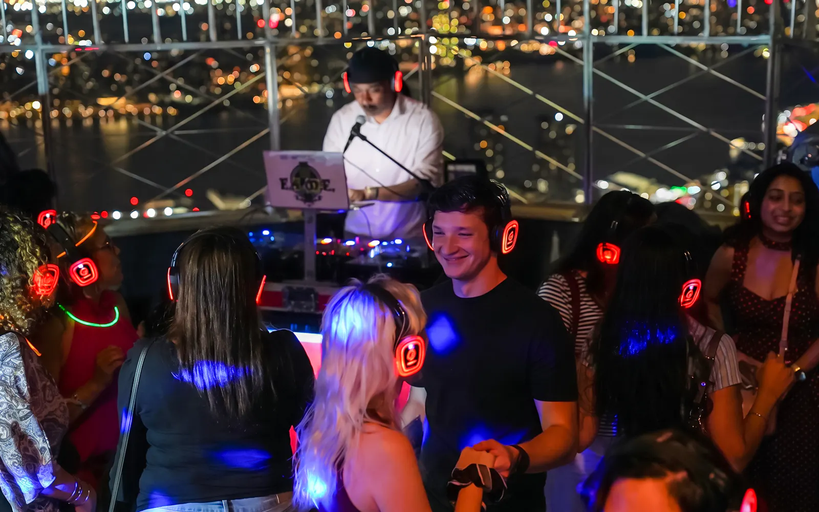 People enjoying a silent disco with headphones at the Empire State Building Observation Deck.