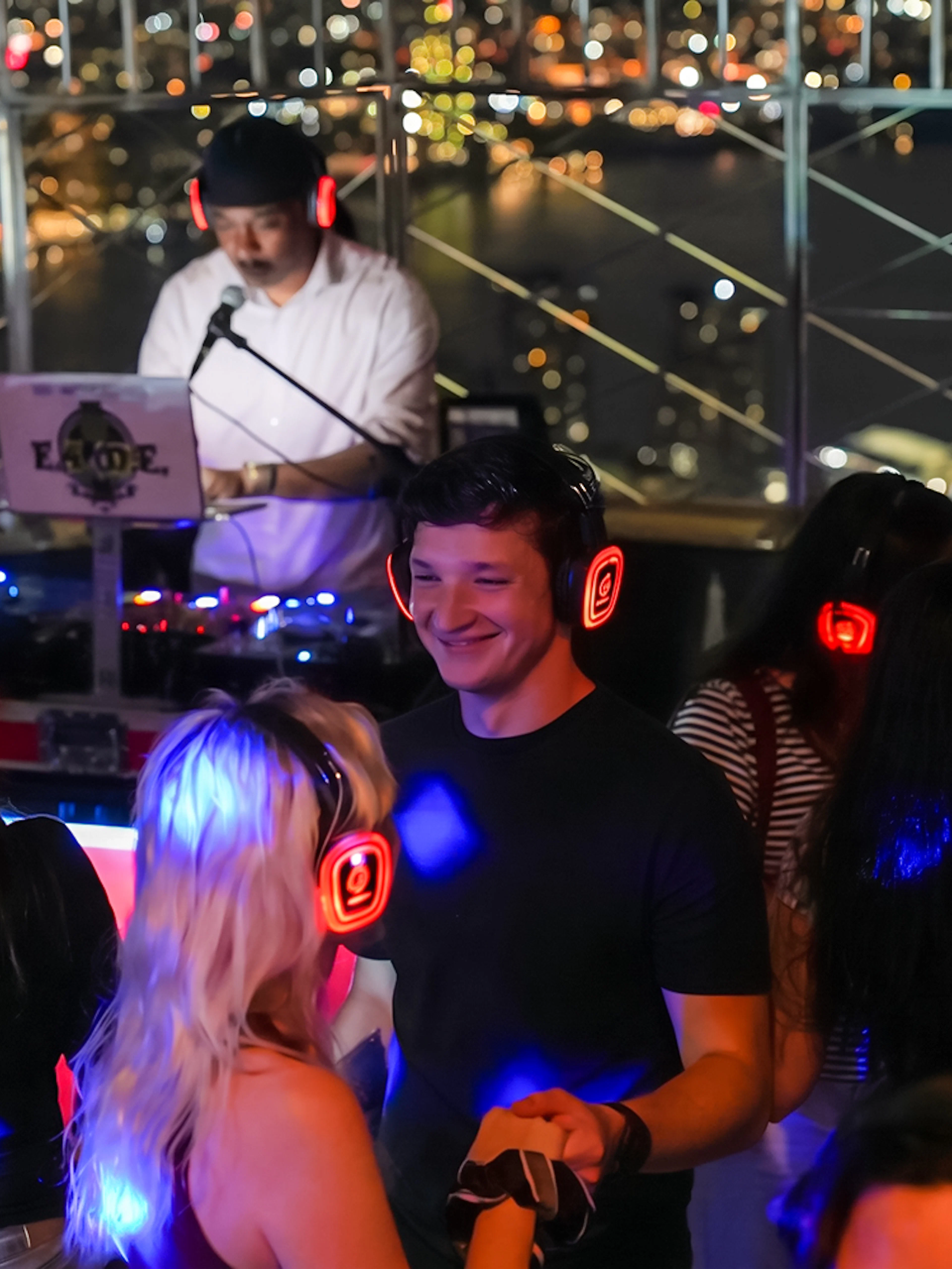 People enjoying a silent disco with headphones at the Empire State Building Observation Deck.