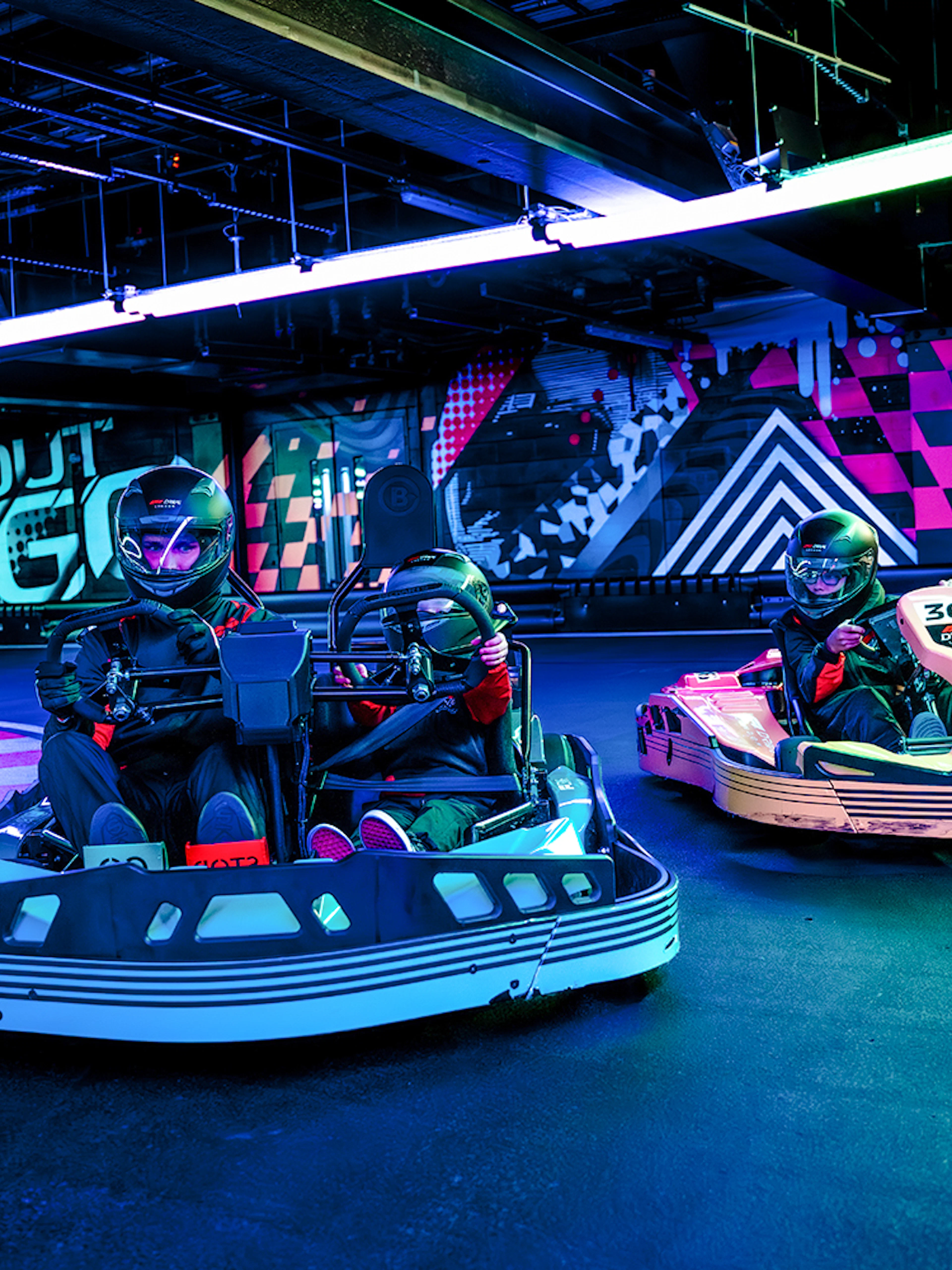 Guests racing go-karts indoors during F1 London Mixed session.