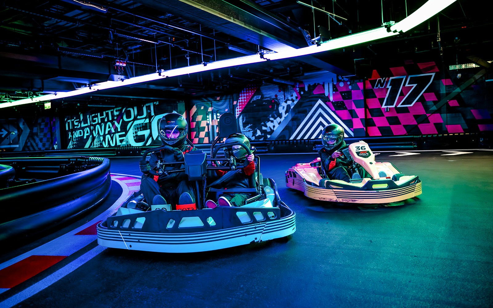 Guests racing go-karts indoors during F1 London Mixed session.