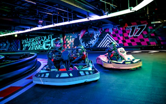 Guests racing go-karts indoors during F1 London Mixed session.