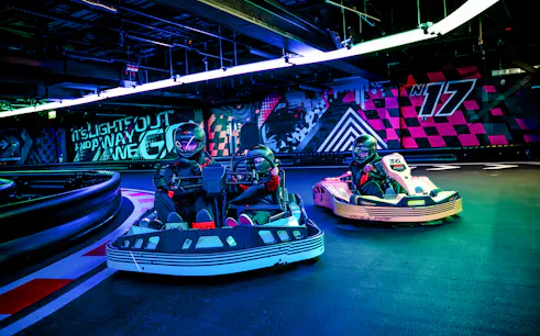 Guests racing go-karts indoors during F1 London Mixed session.