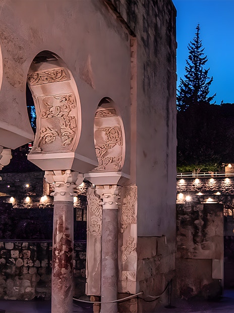 Arched columns illuminated at night in Medina Azahara, Córdoba.