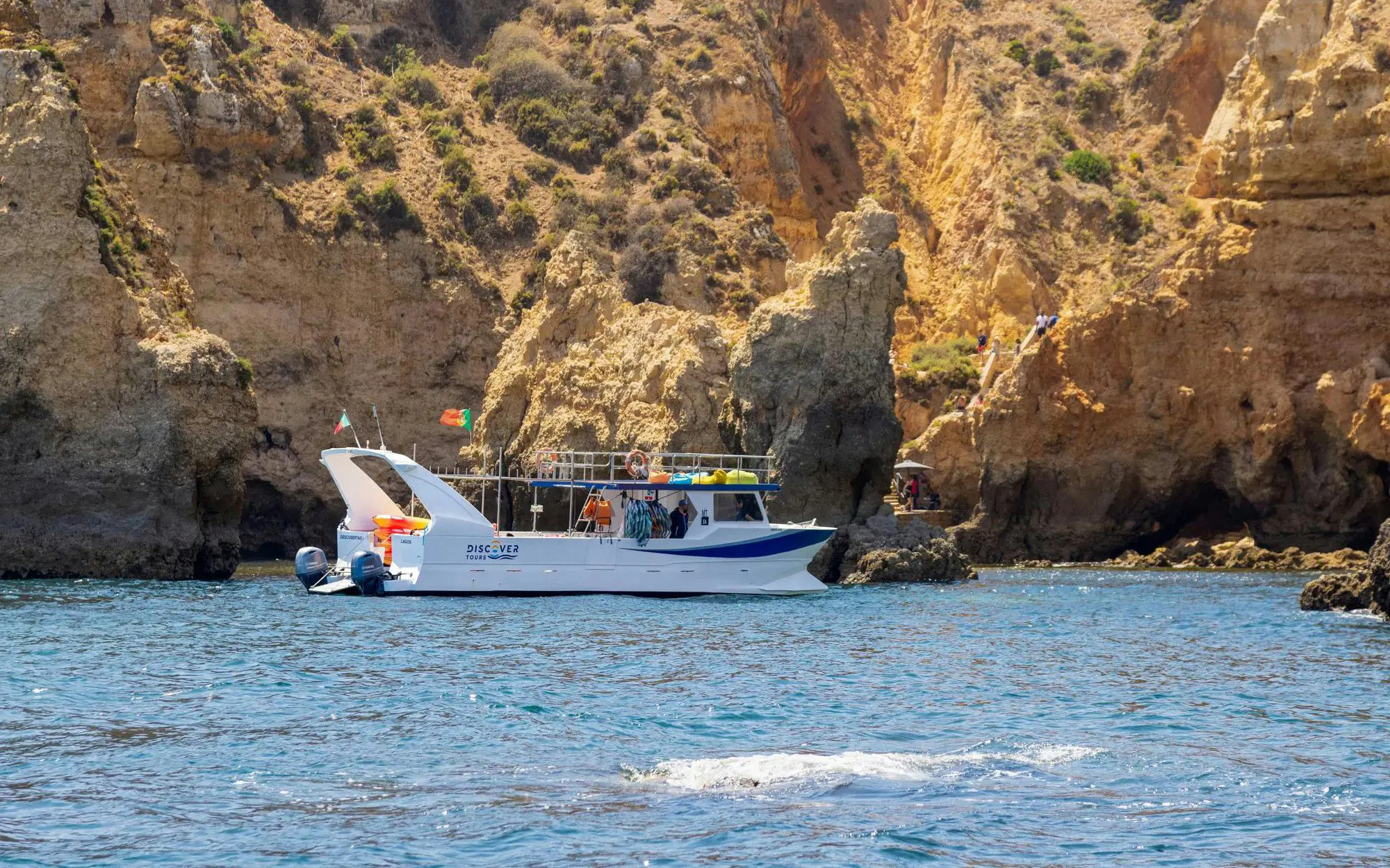 Boat near cliffs on Ponta da Piedade Algarve kayak tour.