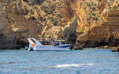 Boat near cliffs on Ponta da Piedade Algarve kayak tour.