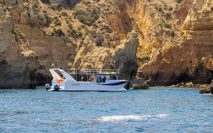 Boat near cliffs on Ponta da Piedade Algarve kayak tour.