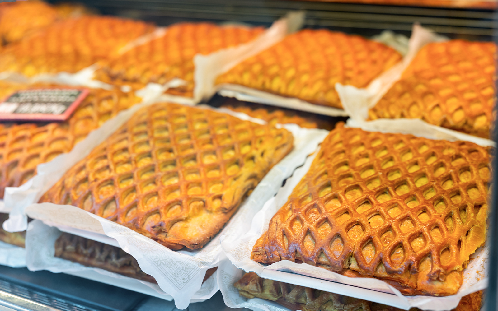Hornazo pastries with lattice crust on display in a Spanish bakery for Easter.