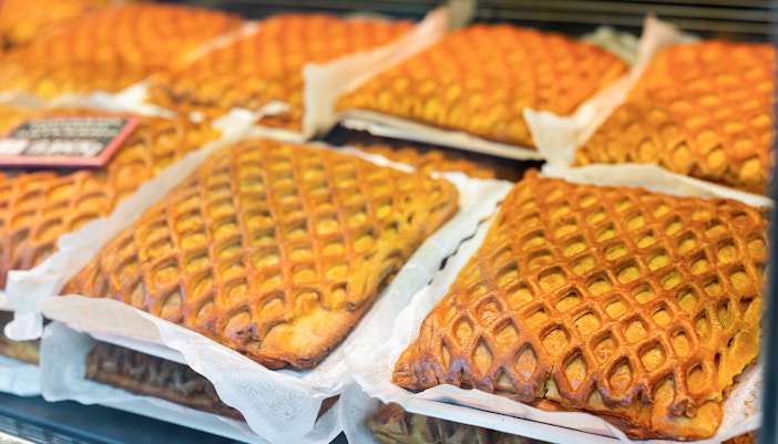 Hornazo pastries with lattice crust on display in a Spanish bakery for Easter.