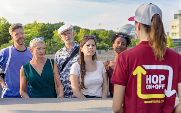 Tour guide explaining to a group during the Stromma Hop-On Hop-Off Berlin Tour.