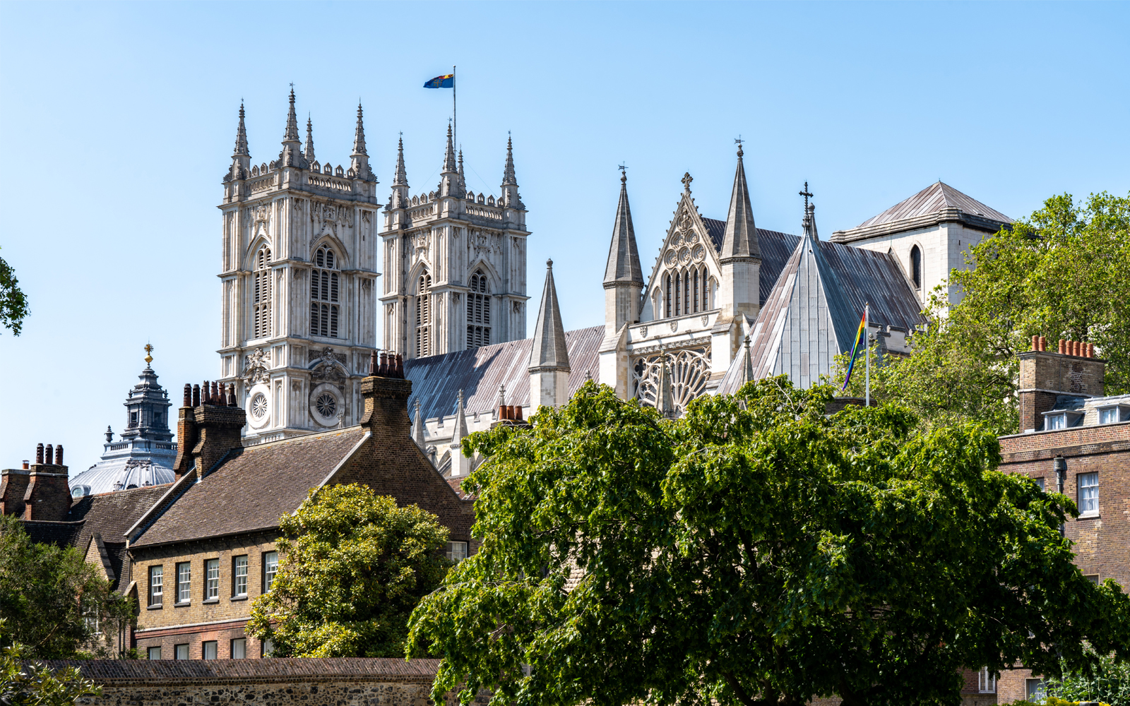 Westminster Abbey towers behind trees in London, England.