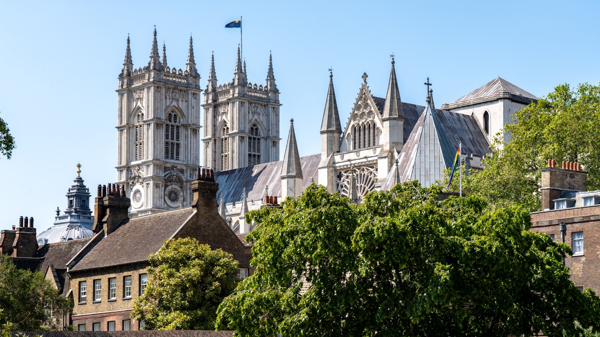 Westminster Abbey towers behind trees in London, England.