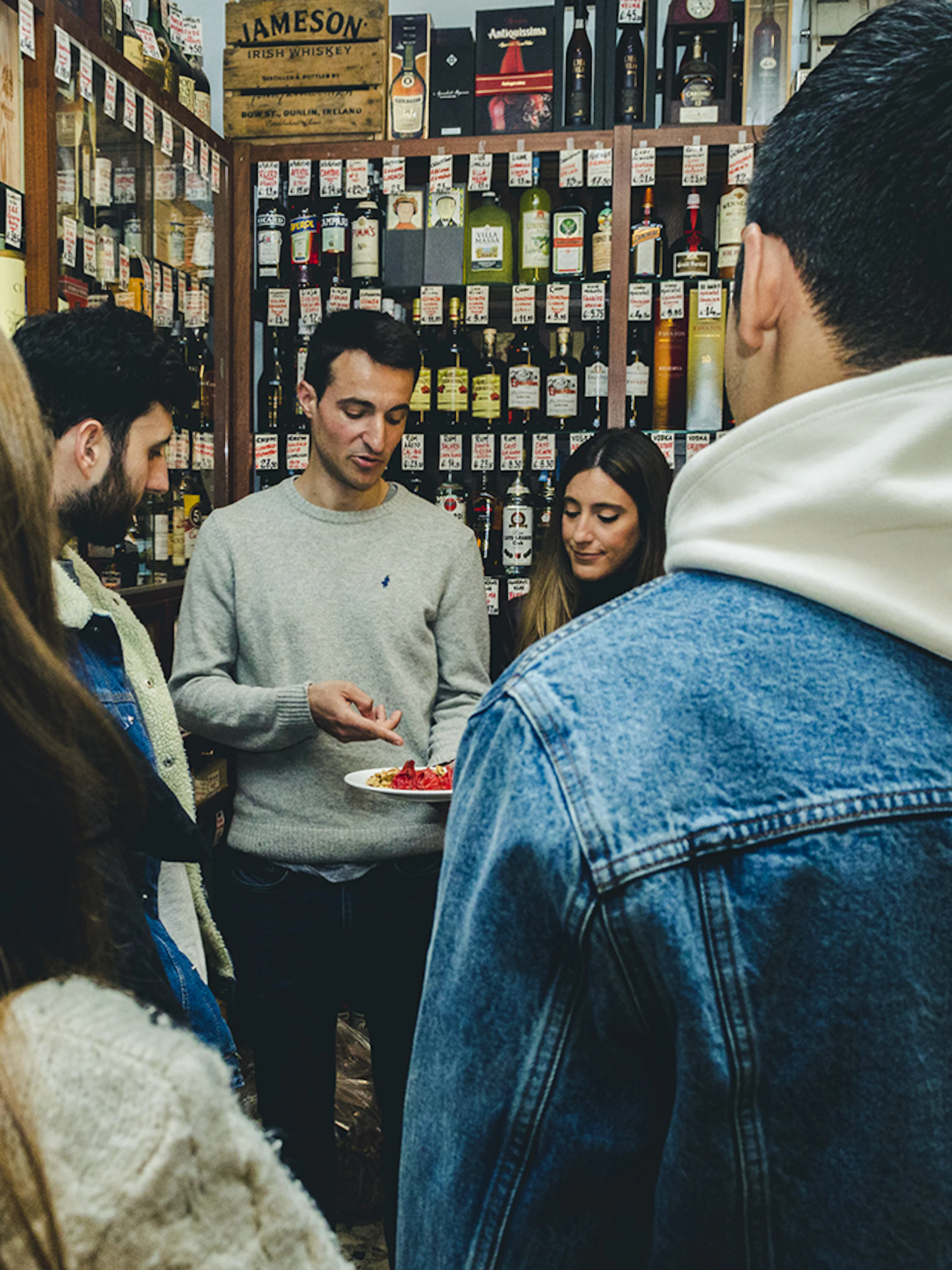 Group tasting wine and food in a Porto shop during a tour.
