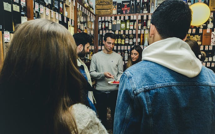 Group tasting wine and food in a Porto shop during a tour.